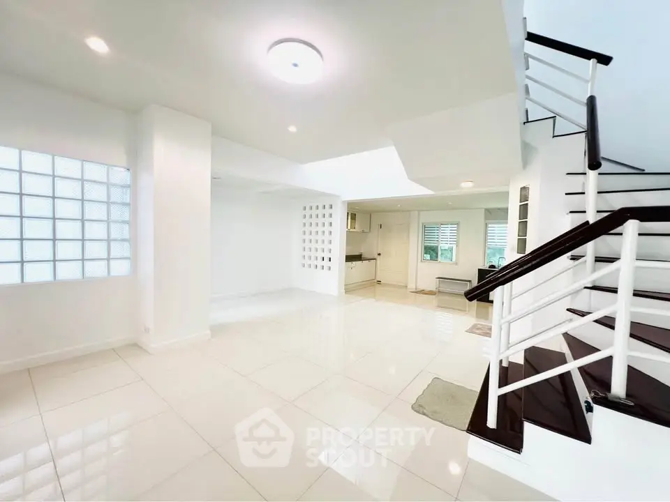 Spacious modern interior with sleek staircase and open layout kitchen