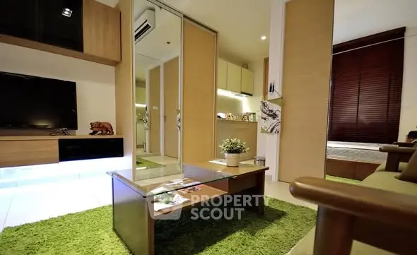 Modern living room with stylish decor and green accents, featuring a cozy seating area and sleek furniture.