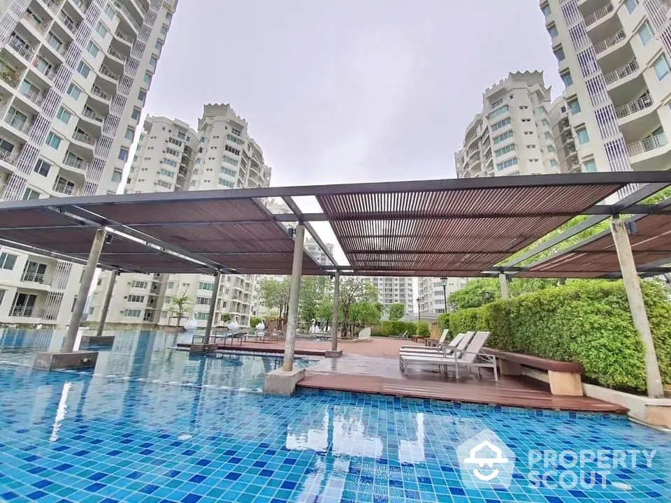 Luxurious condominium pool area with modern design and relaxing sun loungers.