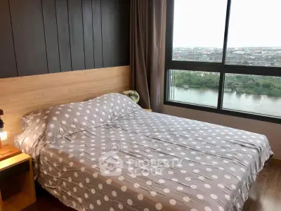 Spacious bedroom with large window offering stunning river view in modern apartment.