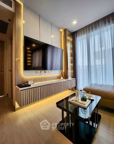 Modern living room with sleek design, large TV, and ambient lighting in a stylish apartment.