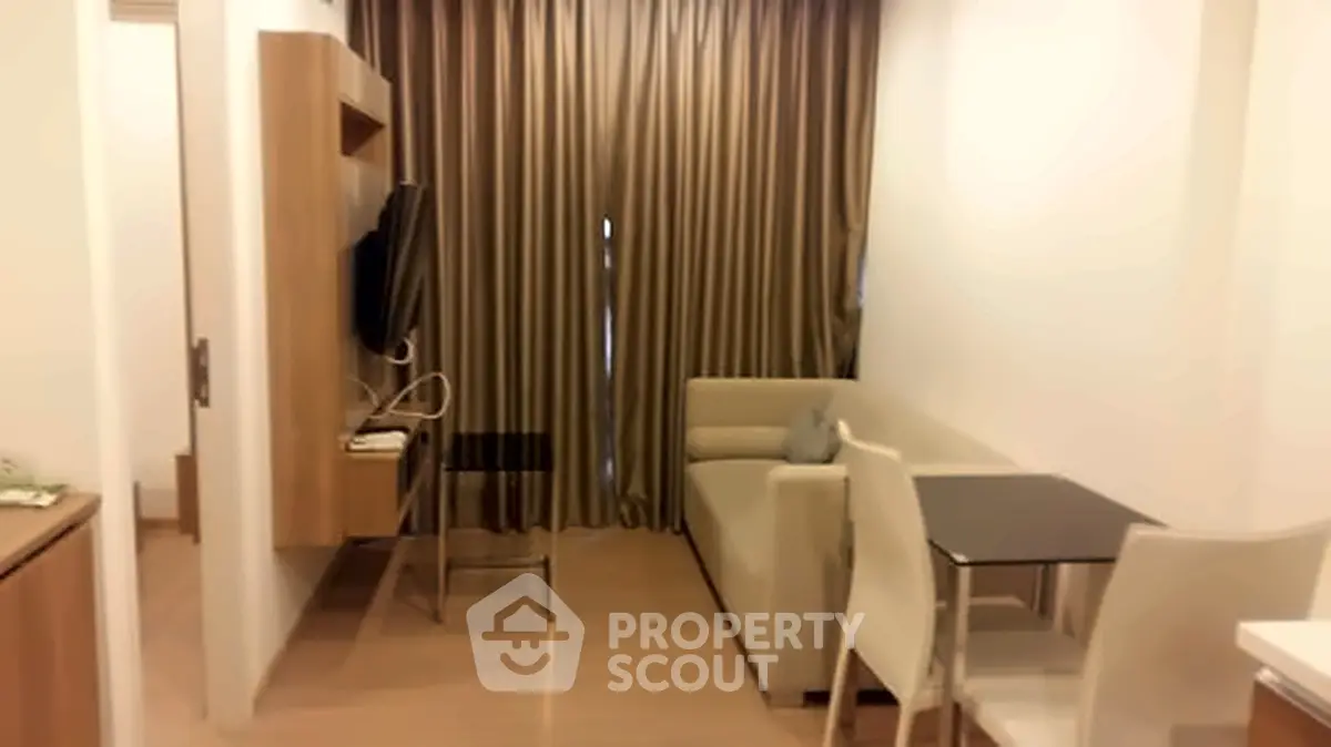 Cozy living room with modern furniture and elegant curtains in a compact apartment.