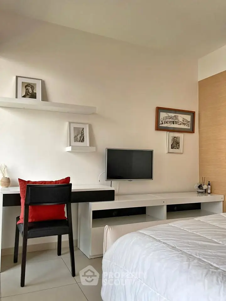 Modern bedroom with sleek desk, wall-mounted TV, and stylish decor for a cozy and functional living space.