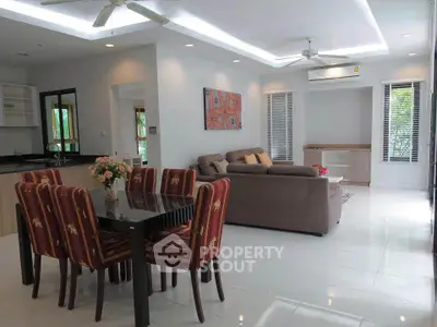 Spacious living room with modern decor and open layout, featuring dining area and comfortable seating.