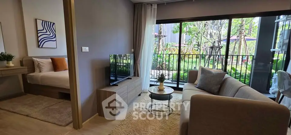 Modern living room with garden view, featuring cozy seating and stylish decor in a bright, open space.