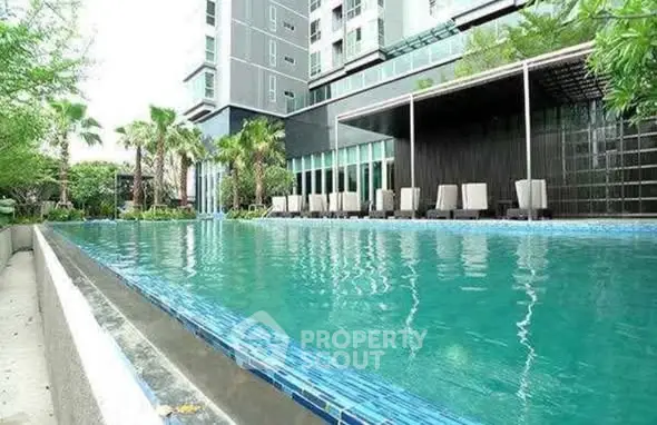 Luxurious apartment complex with a stunning outdoor pool and lush greenery.