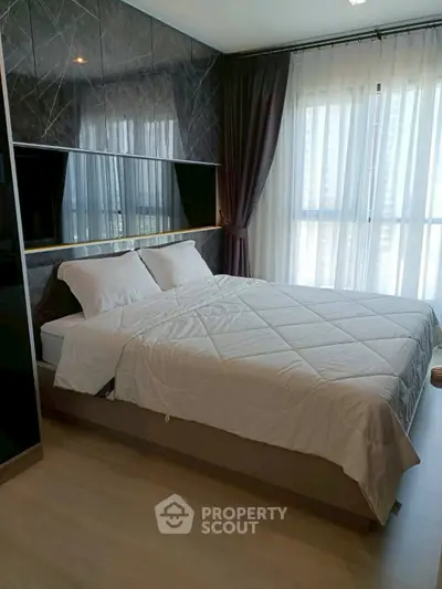 Luxurious bedroom with modern decor and large window offering natural light