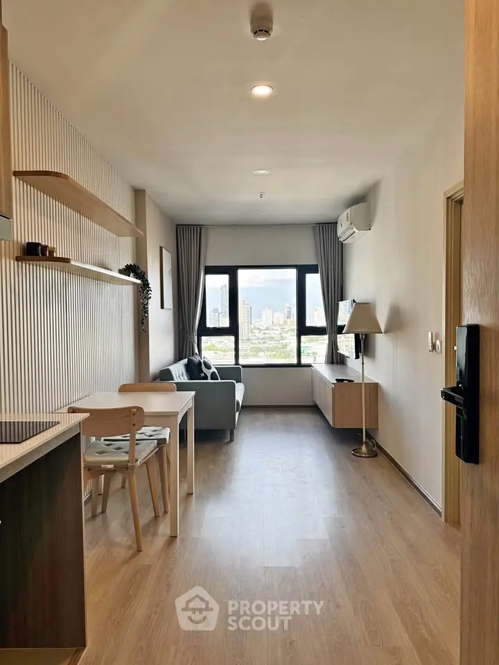 Modern living room with city view, featuring wooden flooring and stylish furniture.