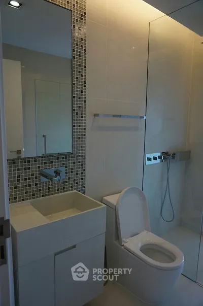Modern bathroom with sleek fixtures and glass shower enclosure