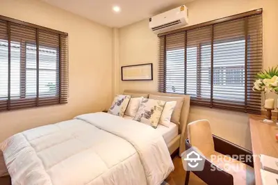 Cozy bedroom with modern decor and ample natural light, featuring a comfortable bed and stylish furnishings.