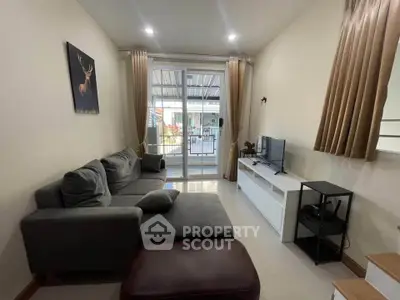 Cozy living room with modern decor and large sliding glass doors leading to a balcony.