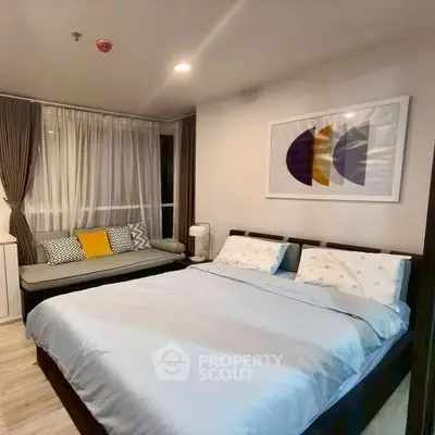 Cozy bedroom with modern decor and large window seating area.