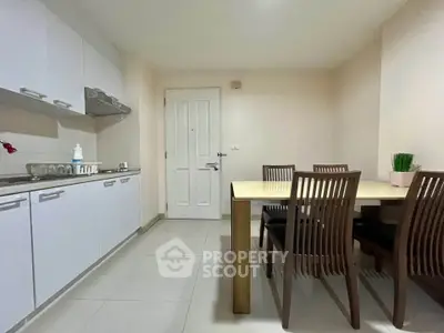 Modern kitchen with dining area featuring sleek cabinetry and a spacious table for family meals.