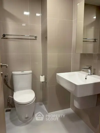 Modern bathroom with sleek fixtures and neutral tiles, perfect for a contemporary home.