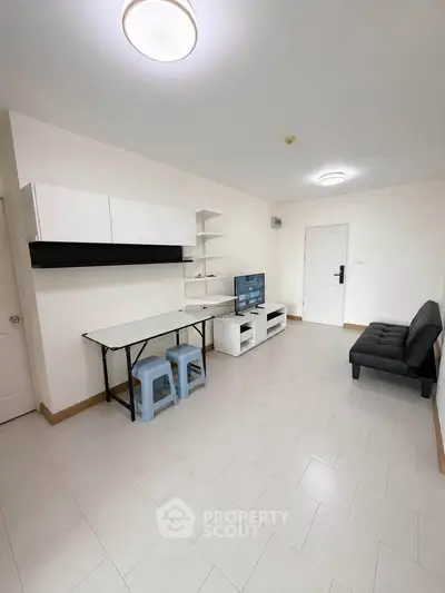 Spacious living room with modern furniture and ample natural light, perfect for relaxation and entertainment.