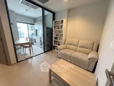 Modern living room with cozy sofa and open kitchen layout in stylish apartment.