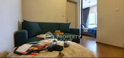 Cozy living room with modern sofa and view into a stylish bedroom