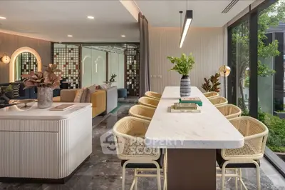Luxurious open-plan living room with modern decor and garden view, featuring stylish furniture and elegant lighting.