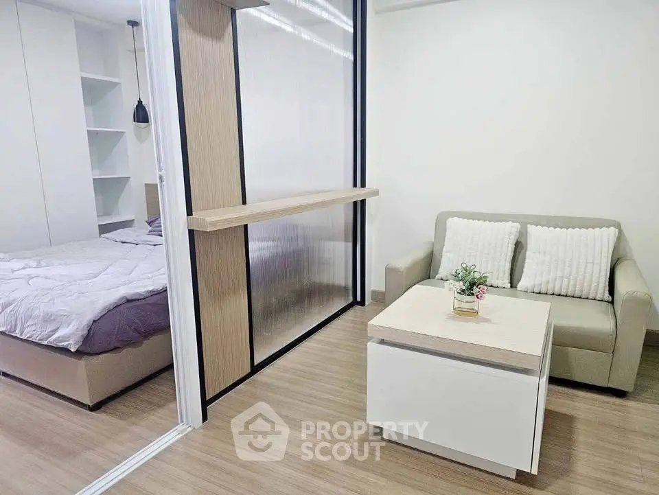 Modern studio apartment with cozy living area and stylish bedroom divider.