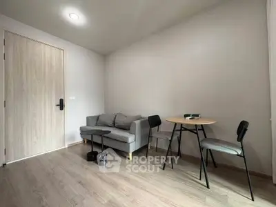 Modern minimalist living room with cozy gray sofa and stylish dining set.