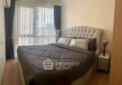 Elegant bedroom with plush bed and large window in modern apartment
