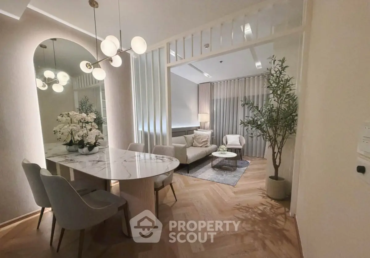 Elegant modern living room with stylish dining area and cozy seating, featuring chic lighting and decor.