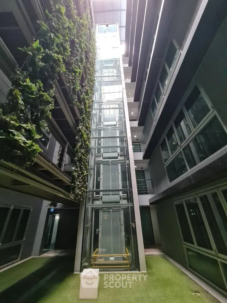 Modern building with glass elevator and vertical garden