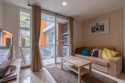Cozy living room with balcony view, modern decor, and natural light in urban apartment.