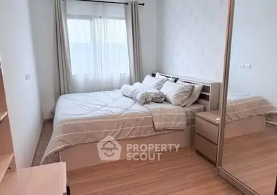 Cozy bedroom with modern decor and ample natural light, featuring a comfortable bed and mirrored wardrobe.