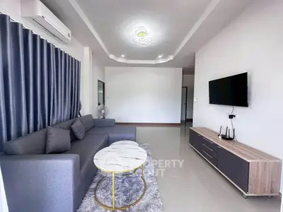 Modern living room with sleek furniture and stylish decor, featuring a comfortable sofa and wall-mounted TV.