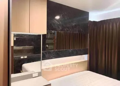 Modern bedroom with stylish marble accent wall and cozy ambiance