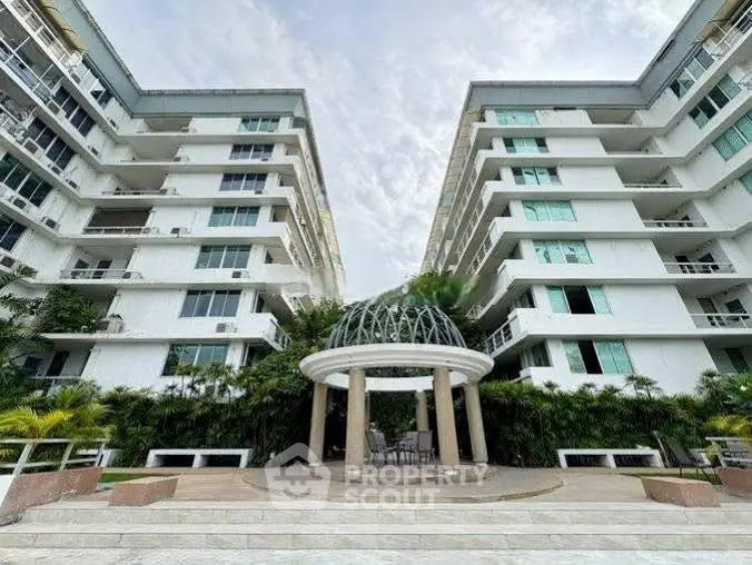 Modern apartment building with lush landscaping and unique architectural design.