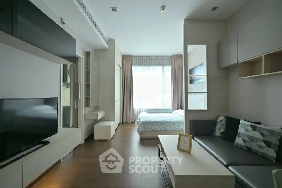 Modern studio apartment with open layout, featuring a cozy living area and a bright bedroom space.
