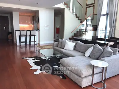 Luxurious open-plan living room with modern decor and stylish staircase