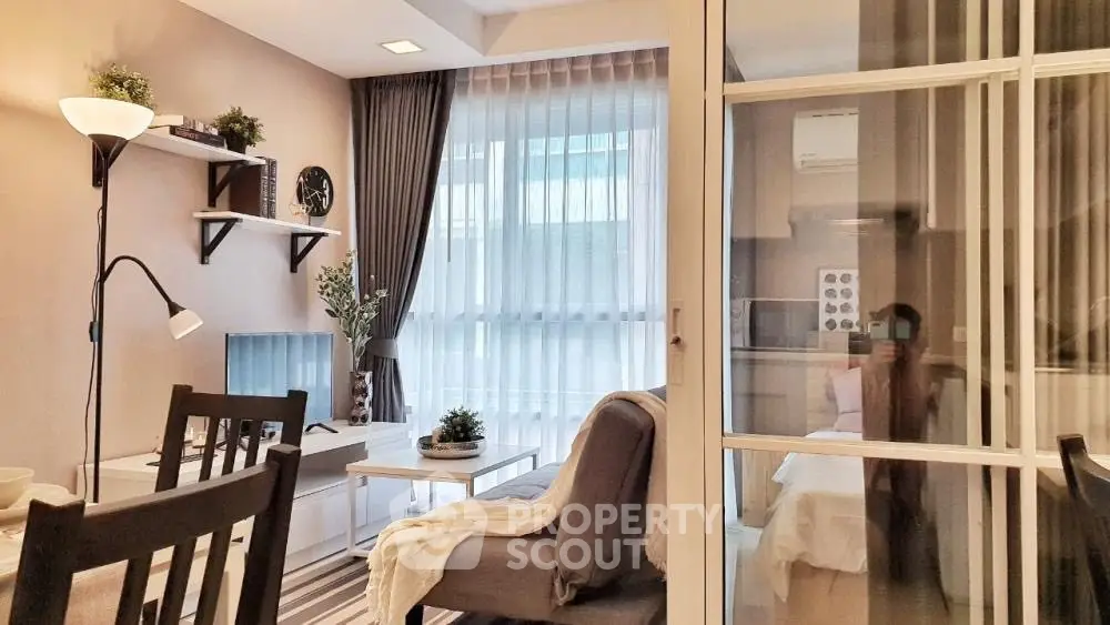 Modern living room with stylish decor and natural light, featuring cozy seating and elegant shelving.