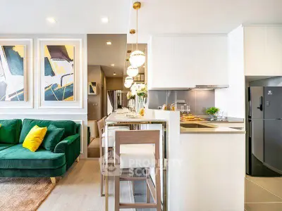 Modern open-plan kitchen and living room with stylish decor and green sofa.