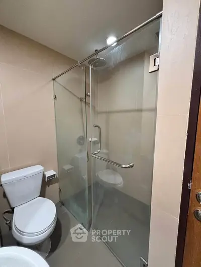 Modern bathroom with glass shower enclosure and sleek fixtures.