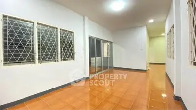 Spacious empty room with tiled floor and large windows, ideal for customization.