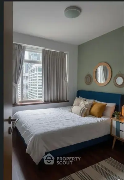 Cozy bedroom with city view, stylish decor, and natural light.