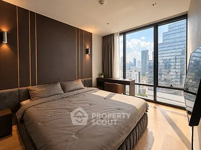 Luxurious bedroom with city view and modern decor in high-rise apartment.