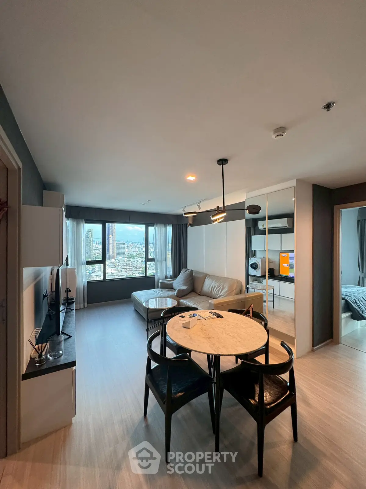 Modern living room with city view, featuring sleek furniture and open layout, perfect for urban living.