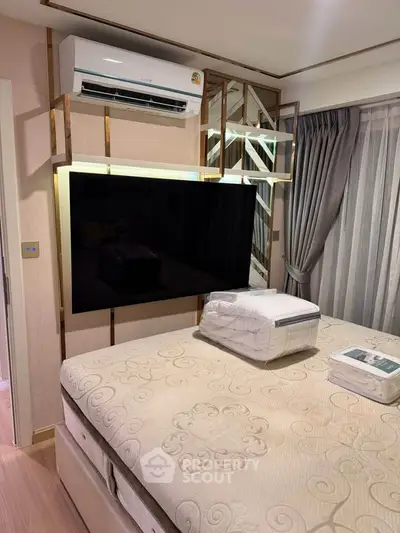 Modern bedroom with stylish decor, featuring a wall-mounted TV and air conditioning unit.