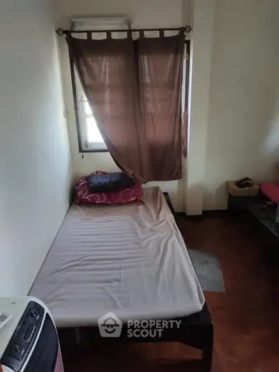 Cozy bedroom with single bed and window, ideal for minimalist living.