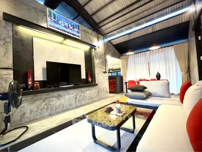 Modern living room with stylish decor and high ceiling, featuring a cozy seating area and elegant lighting.
