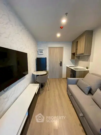 Modern living room with sleek furniture and open kitchen layout in a stylish apartment.