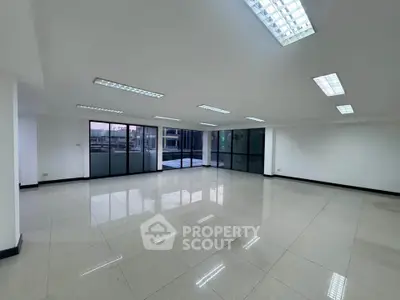 Spacious modern office space with large windows and tiled flooring
