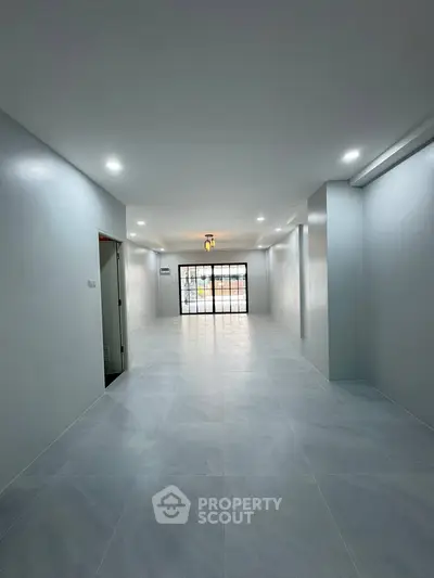 Spacious modern interior with sleek flooring and large windows for natural light.