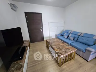Modern living room with stylish sofa and marble coffee table, featuring sleek TV setup and wooden flooring.