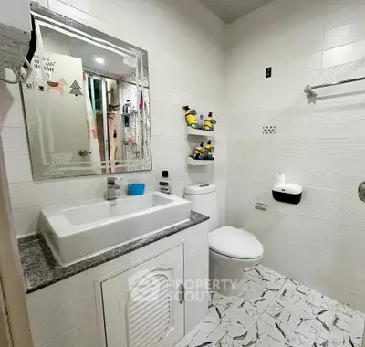 Modern bathroom with stylish vanity and decorative shelving