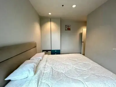Cozy bedroom with modern decor and ample natural light, featuring a comfortable bed and built-in wardrobe.